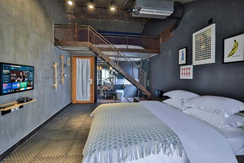 桐乡乌镇秋喜艺术酒店的一间带大床和楼梯的卧室