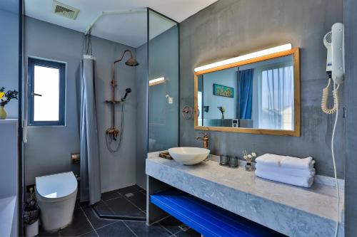 桐乡乌镇秋喜艺术酒店的一间带水槽和镜子的浴室