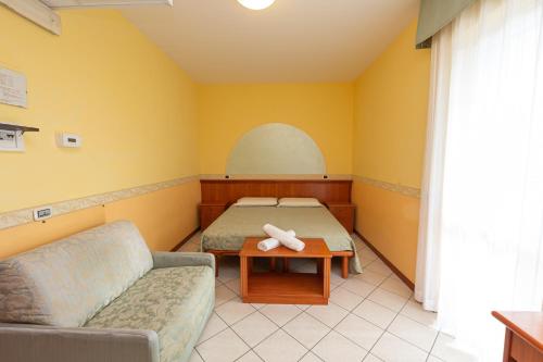 阿布鲁齐的罗塞托Hotel Roma Sul Mare的客房设有床、沙发和桌子。