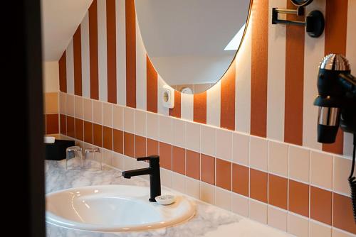 黑灵斯多夫Villa Usedom的浴室设有水槽,铺有橙色和白色瓷砖。