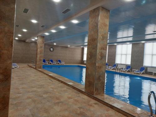 萨克德佐尔镇Tsaghkadzor, Alvina Complex Apartment 163的大楼内带蓝色椅子的大型游泳池
