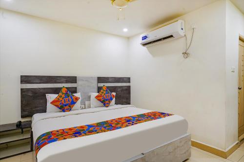 维杰亚瓦达FabHotel Ambika Elite的白色客房,配有色彩缤纷的枕头