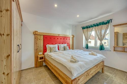 拉特西Apartments Viktor的一间卧室配有一张大床和红色床头板