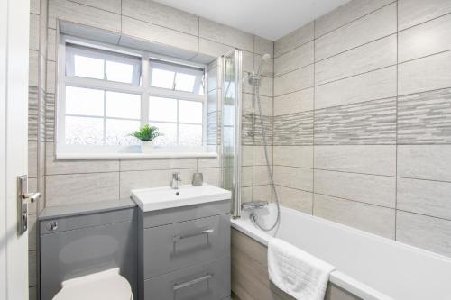 KentGravesend 3 Beds By JADA Homes的浴室配有卫生间、盥洗盆和浴缸。