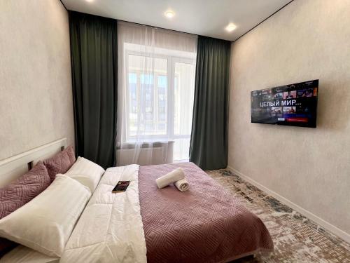 阿斯塔纳Уютная квартира в городе Астана, возле Барыс арена的一间卧室设有一张床和一个窗口