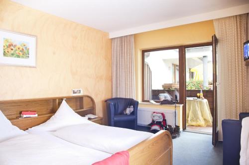 维林根Bio-Hotel Upländer Hof的配有一张床和一把椅子的酒店客房