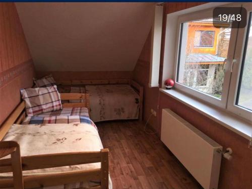 拉加希姆斯Dimanti的小房间设有两张床和窗户