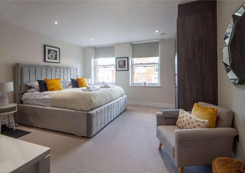 伦敦Kensington High Street One Bed的一间卧室配有一张床、一张沙发和一把椅子