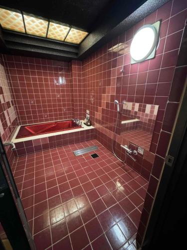 栗东プラザ太陽的红色瓷砖浴室设有红色瓷砖淋浴