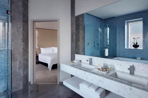 伊斯坦布尔伊斯坦布尔希什利万豪酒店 的一间带水槽和镜子的浴室以及一张床