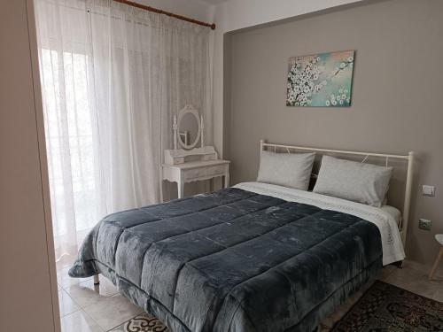 亚历山德鲁波利斯J&B Home的一间卧室配有一张大床和镜子