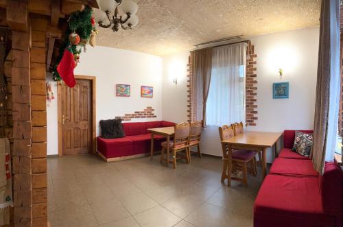 斯拉夫西克Тіна的客厅配有红色的沙发和桌子