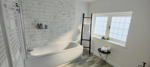 林肯Hampshire Charming House的带窗户的浴室内的白色浴缸