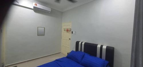 Hutan MelintangLa Familia Homestay Bagan Datuk的一间卧室配有一张带蓝色枕头的床