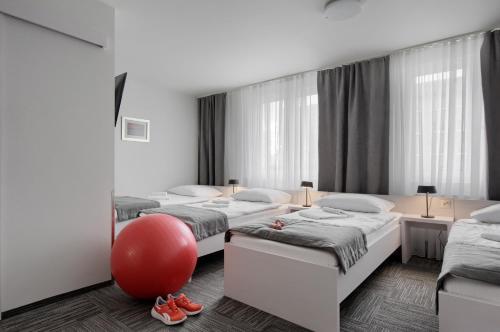 什切青Jantar Resort的一间房间,里面装有四张床和红色的球