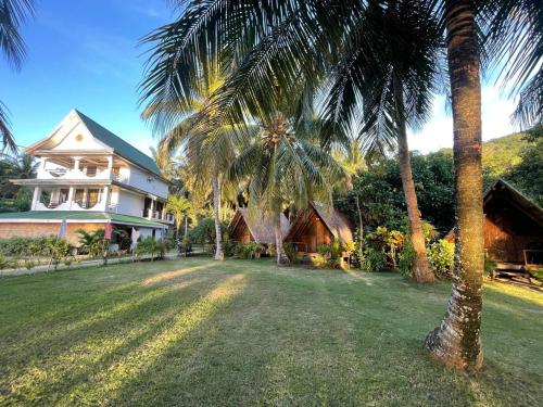 FerrolBinucot Lodge的一座棕榈树大房子前面
