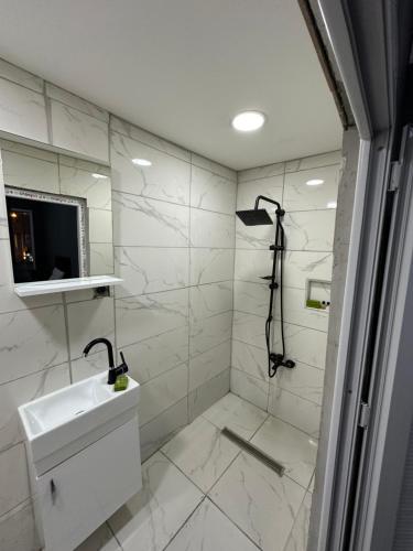 YıldırımREYNA OTEL的白色的浴室设有水槽和淋浴。
