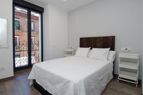 马德里We Madrid Casa Duque的卧室设有一张白色大床和一扇窗户。