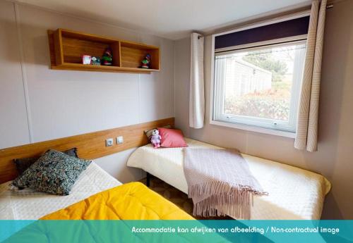 劳雷尔苏格Siblu camping Lauwersoog的小房间设有两张床和窗户