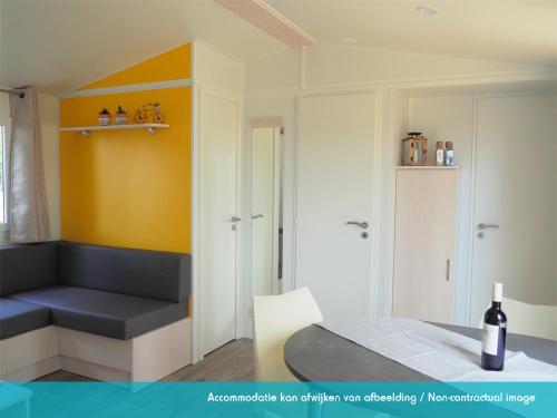 劳雷尔苏格Siblu camping Lauwersoog的一间设有一张床和一瓶葡萄酒的客房
