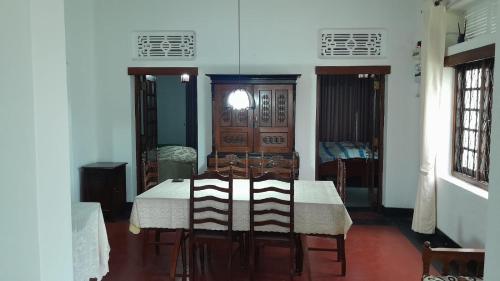 哈普特莱Rajavilla的一间配备有白色桌椅的用餐室