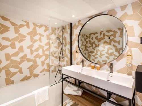 戛纳戛纳曼德里尔美居酒店的一间带水槽和镜子的浴室