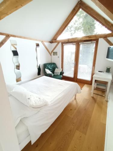 哈斯尔米尔LITTLE OAK - Kingsize Double Oak Studio - Sleeps 2 - Quirky - Rural的一间卧室设有一张床和一个窗口