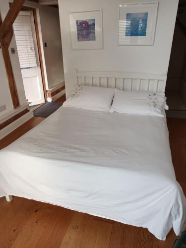 哈斯尔米尔LITTLE OAK - Kingsize Double Oak Studio - Sleeps 2 - Quirky - Rural的一张白色大床,配有白色床单和枕头