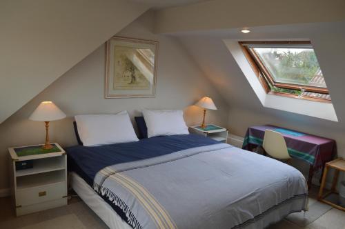 伦敦Wimbledon Views的一间卧室设有床、两张桌子和一扇窗户