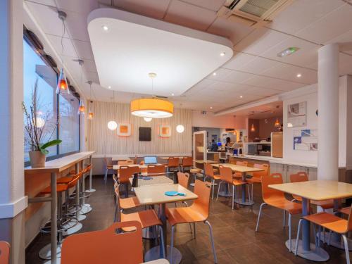 圣康坦ibis budget Saint-Quentin Centre Gare的一间带桌椅和柜台的餐厅