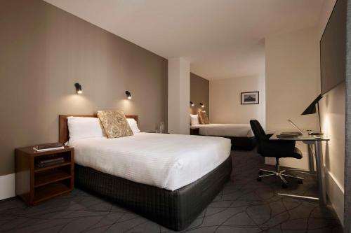 墨尔本维多利亚酒店的酒店客房配有两张床和一张书桌