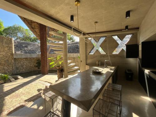 爱妮岛Happiness Kulambo Villa El Nido的厨房配有水槽和带椅子的柜台。