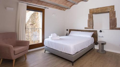 圣胡安-德拉斯阿巴德萨斯Abbatissa Hotel Restaurant的卧室配有床、椅子和窗户。