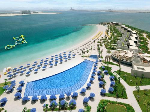 拉斯阿尔卡麦Mövenpick Resort Al Marjan Island的享有海滩空中美景,设有遮阳伞和游泳池