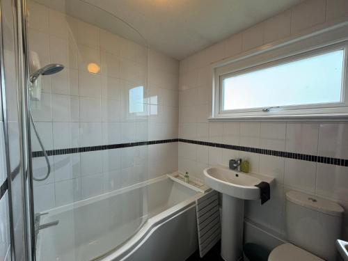 Blackwater Terrace Witham的浴室配有盥洗盆、浴缸和盥洗盆