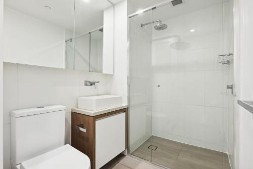 布里斯班Chic 1-Bedroom Apartment with Pool and Gym的浴室配有卫生间、盥洗盆和淋浴。
