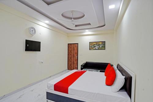 加济阿巴德OYO Flagship Hotel Jojo In的一间卧室配有红色和白色枕头的床