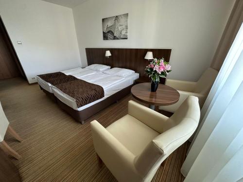 布拉迪斯拉发布拉迪斯拉发酒店 的酒店客房带一张床、一张桌子和椅子