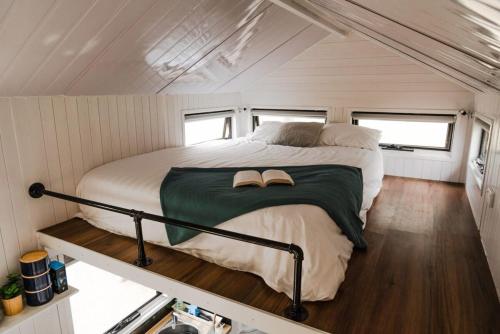 塞斯诺克Odyssean Tiny House B的一个小房子中间的一张床位