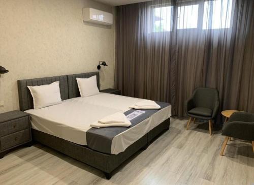 VratsaБългаре的一间卧室配有一张床、两把椅子和一个窗户