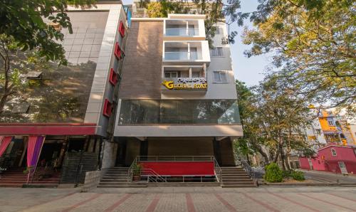 班加罗尔Treebo Trend Global Stay Jayanagar的前面有红色长凳的建筑