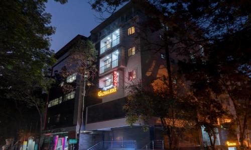 班加罗尔Treebo Trend Global Stay Jayanagar的建筑的侧面有 ⁇ 虹灯标志