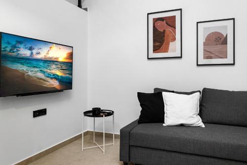 阿斯格罗San Marino Luxury Suites #2的客厅配有沙发和墙上的电视