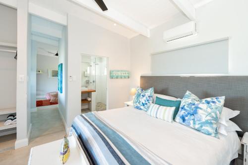 德班The Beach Bungalow的一间卧室配有一张带蓝色和白色枕头的床