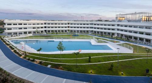波苏埃洛-德阿拉尔孔Student Experience Madrid Pozuelo - Luxury Hostel的一座大型建筑,前面设有一个大型游泳池