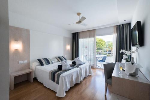 卡拉布兰卡Sagitario Playa的酒店客房设有两张床和电视。