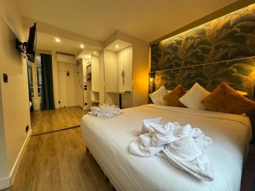 巴黎蒙马特国家酒店的一间卧室配有一张带白色毛巾的床