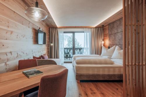 圣维吉利奥Garni Residence Alnö - Adults Only的酒店客房配有一张床铺和一张桌子。