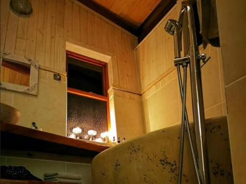 察嫩Waterbessiebos cottage的带浴缸的浴室和窗户。