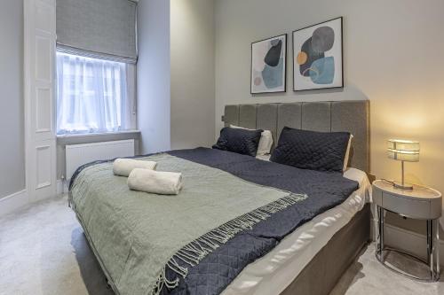 伦敦Green Street Residences by Q Apartments的一间卧室设有一张大床和一个窗户。